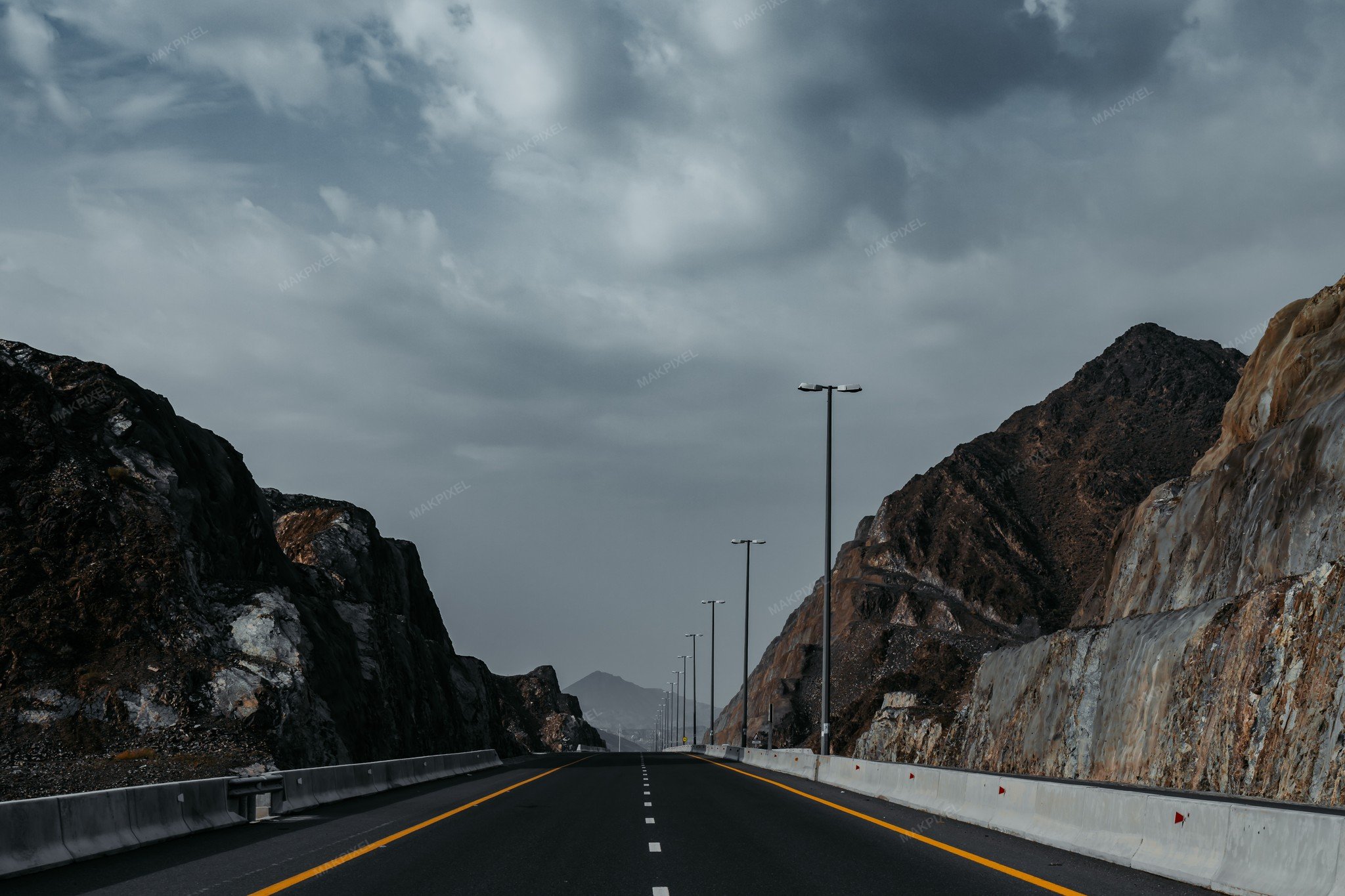 Highway with a scenic view of mountains and a cloudy sky - Full size view