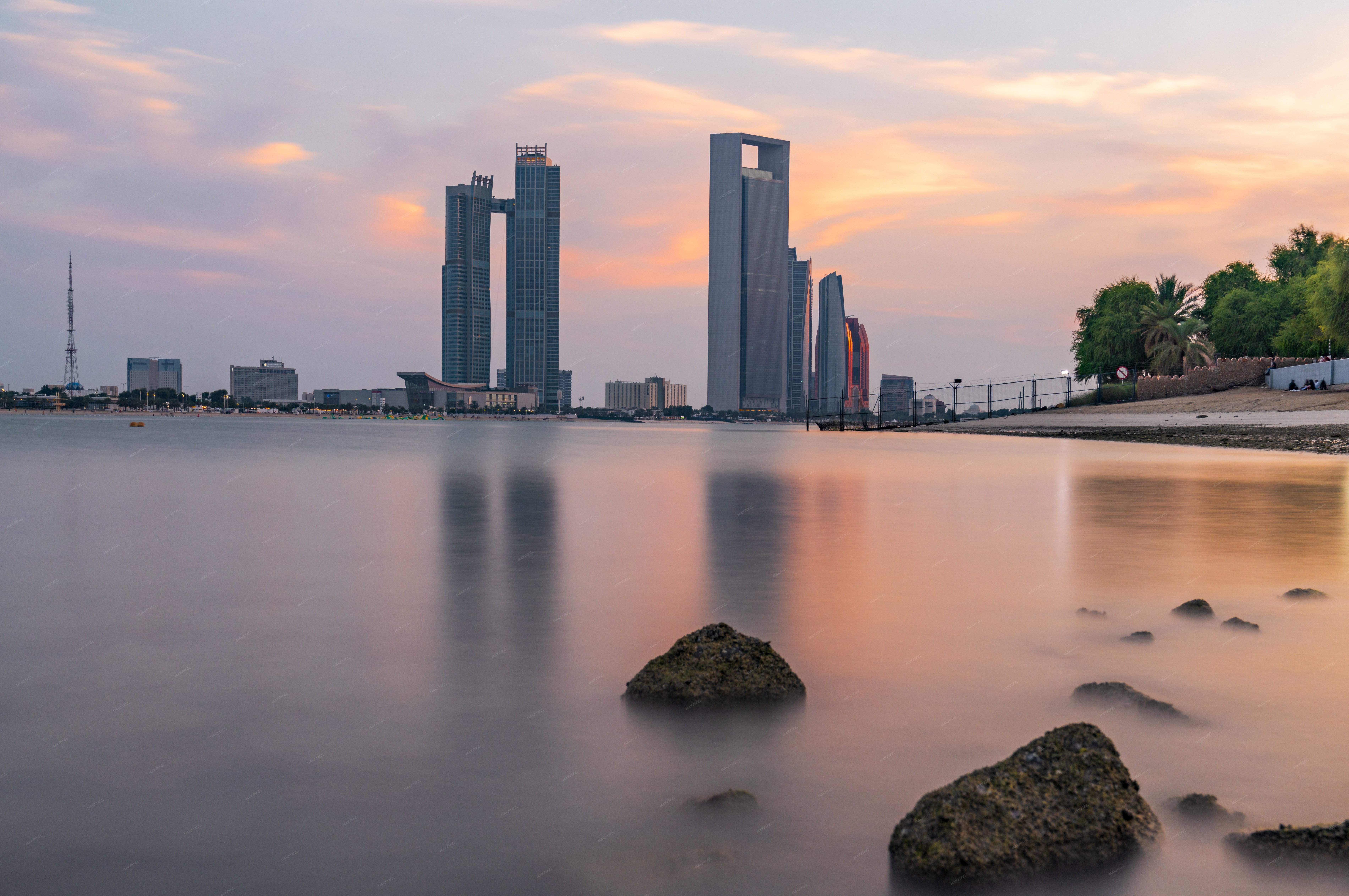 beautiful sunset over a body of water with a city skyline in - Full size view