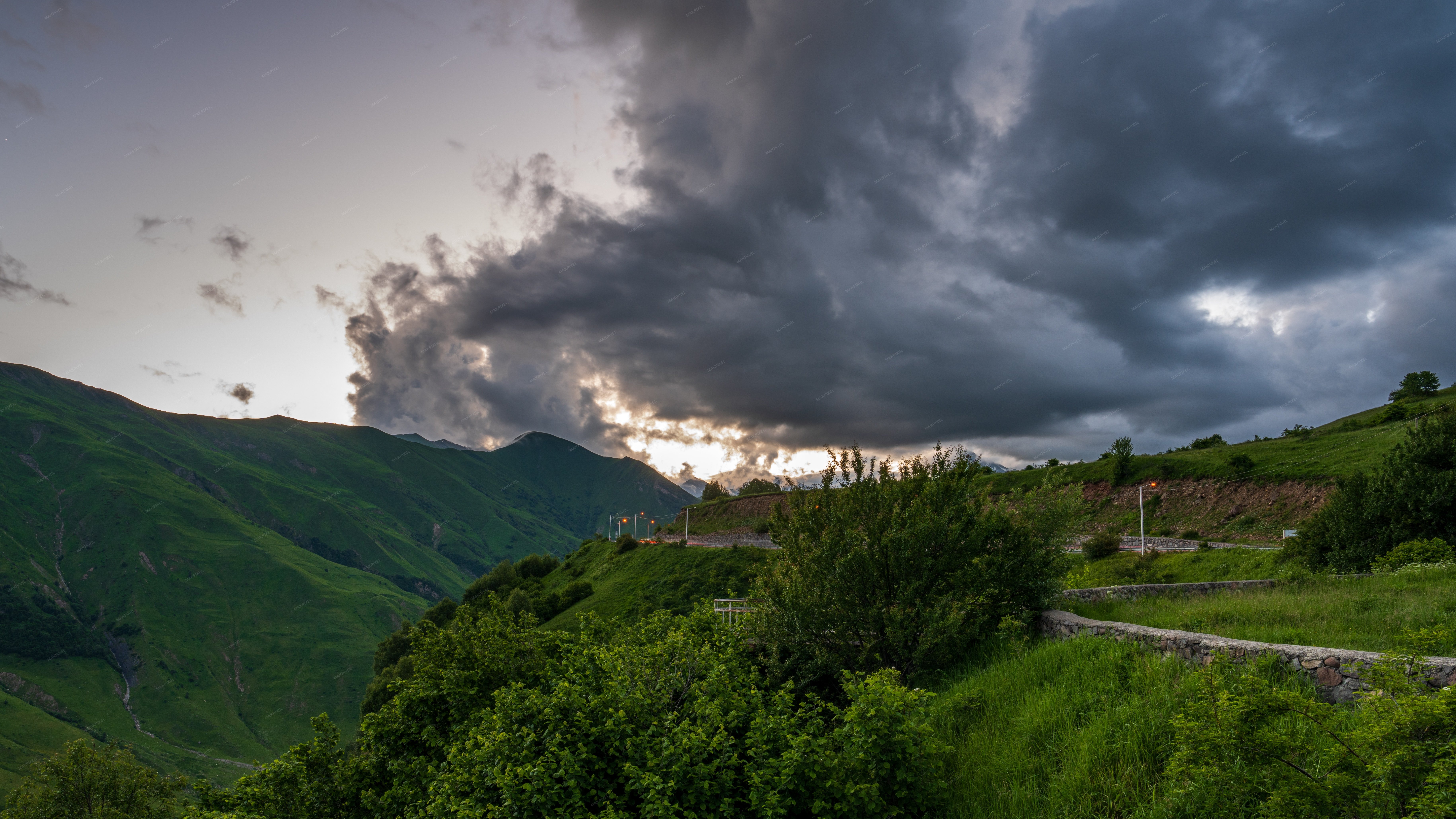 Dramatic Sunset Over Green Mountains In Kazbegi Stock Photo - Full size view