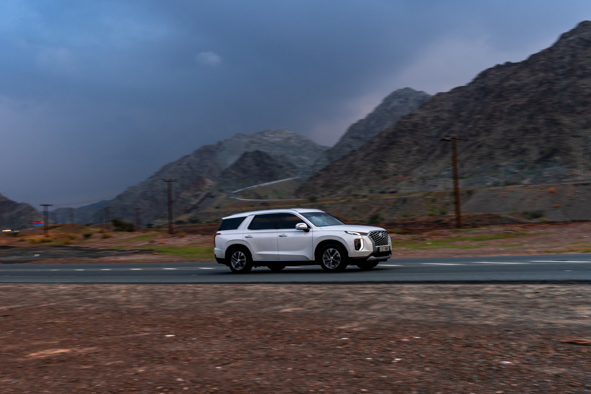 Desert landscape with a vehicle on a road - 2048×1366 stock photo