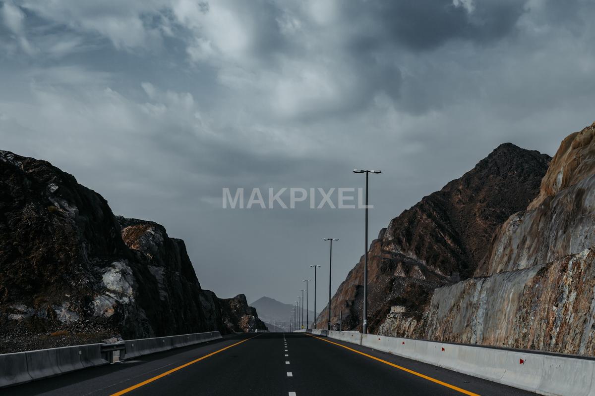 Highway with a scenic view of mountains and a cloudy sky - 2048×1365 stock photo