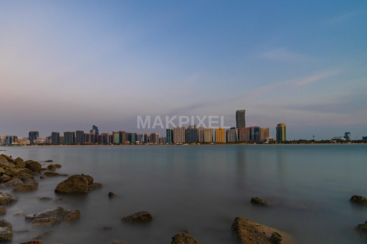 scenic view of a coastal city at sunset, with a skyline - 7823×5215 stock photo