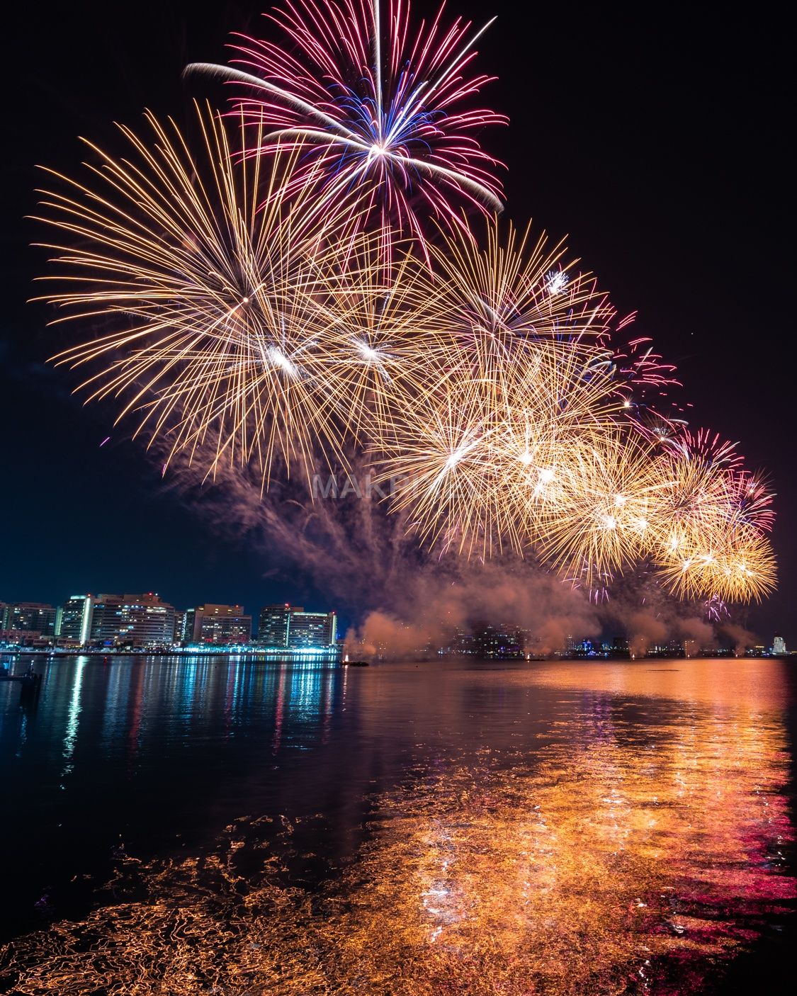UAE Waterfront Fireworks Show – Colorful Night City Skyline Reflection - 1125×1406 stock photo